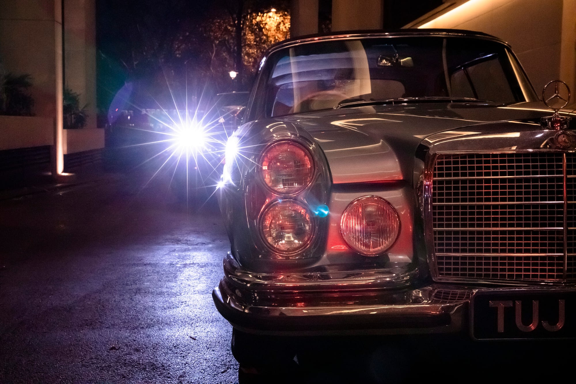 old Mercedes car at night with lights reflections