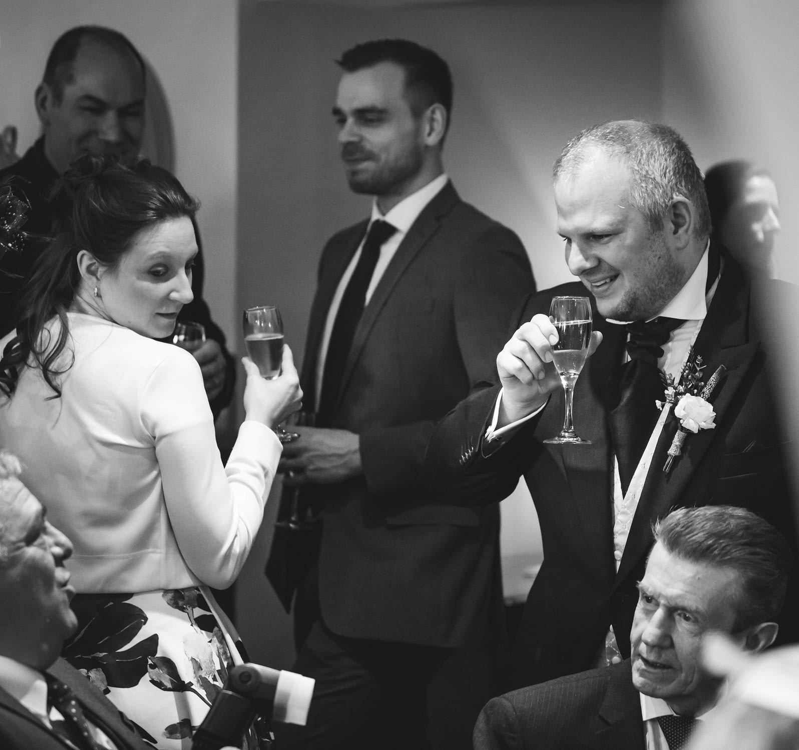 black and white picture of wedding guests chatting together