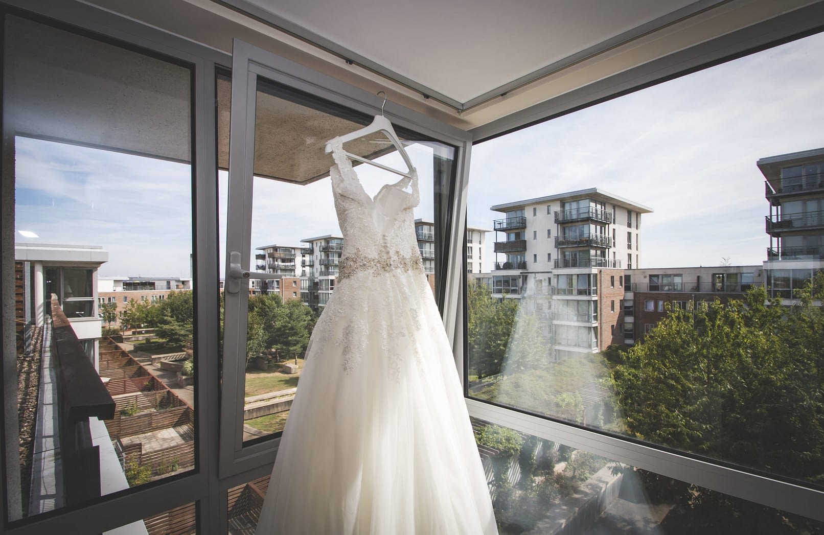 bride's dress hanging up in front of window