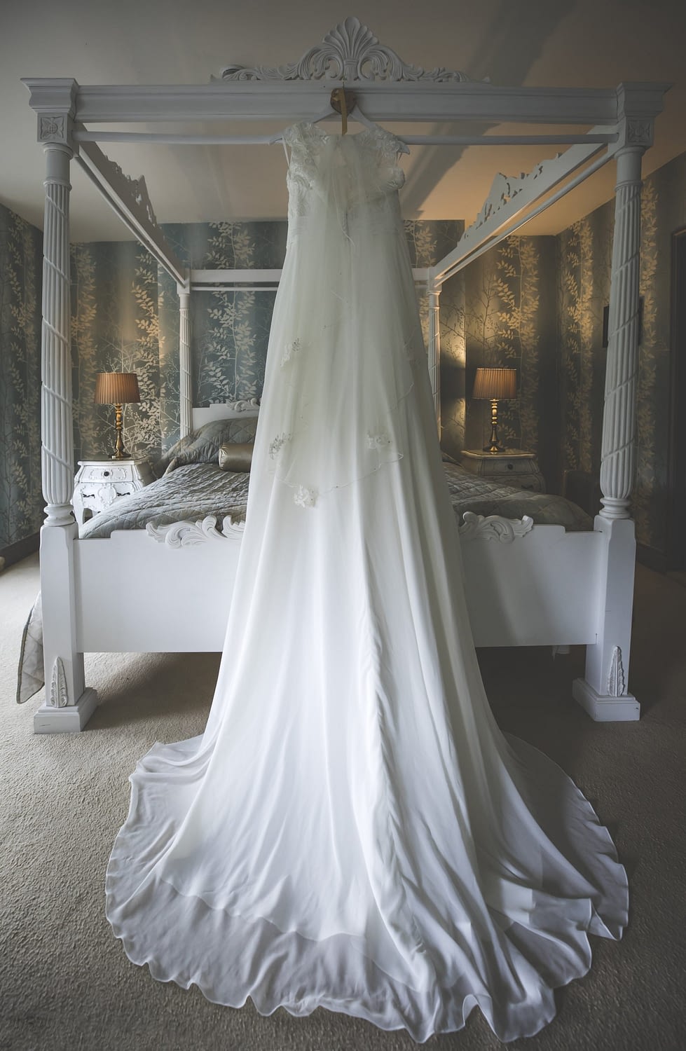 wedding gown hanging on 4 poster bed