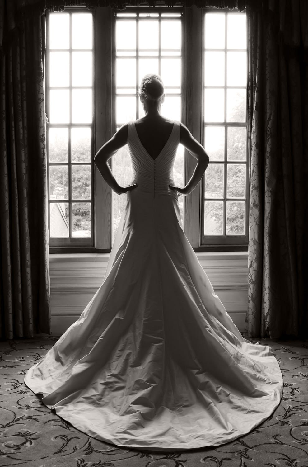 bride standing in front of a window looking out