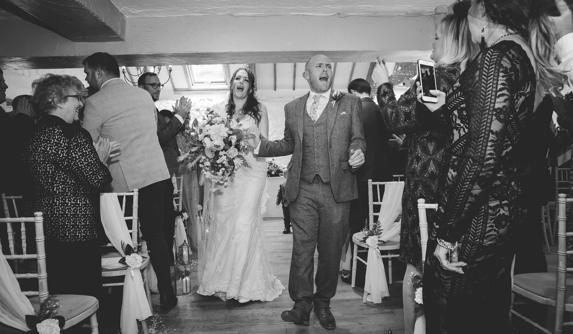 bride and groom walk back up the aisle singing
