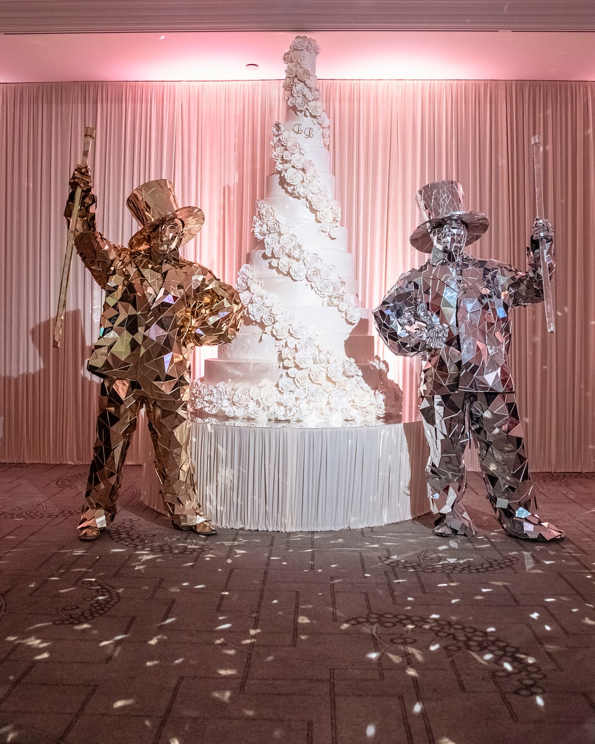 large wedding cake and two people in mirror suits
